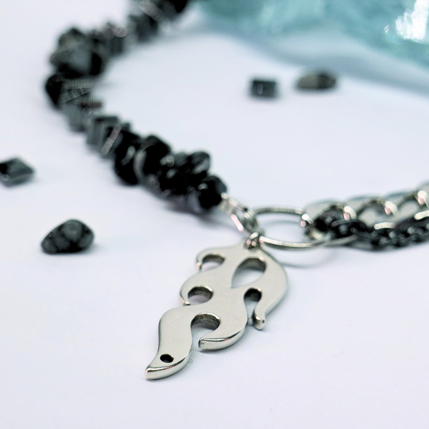 Close-up of stainless-steel chain with flame pendant