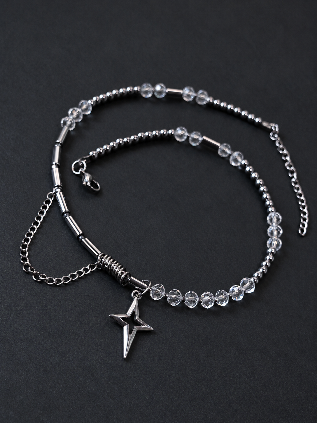 Alternate angled full view of SPECTRAL ARC's crystal and silver hematite necklace, silver-plated North Star pendant and adjustable stainless steel closure.