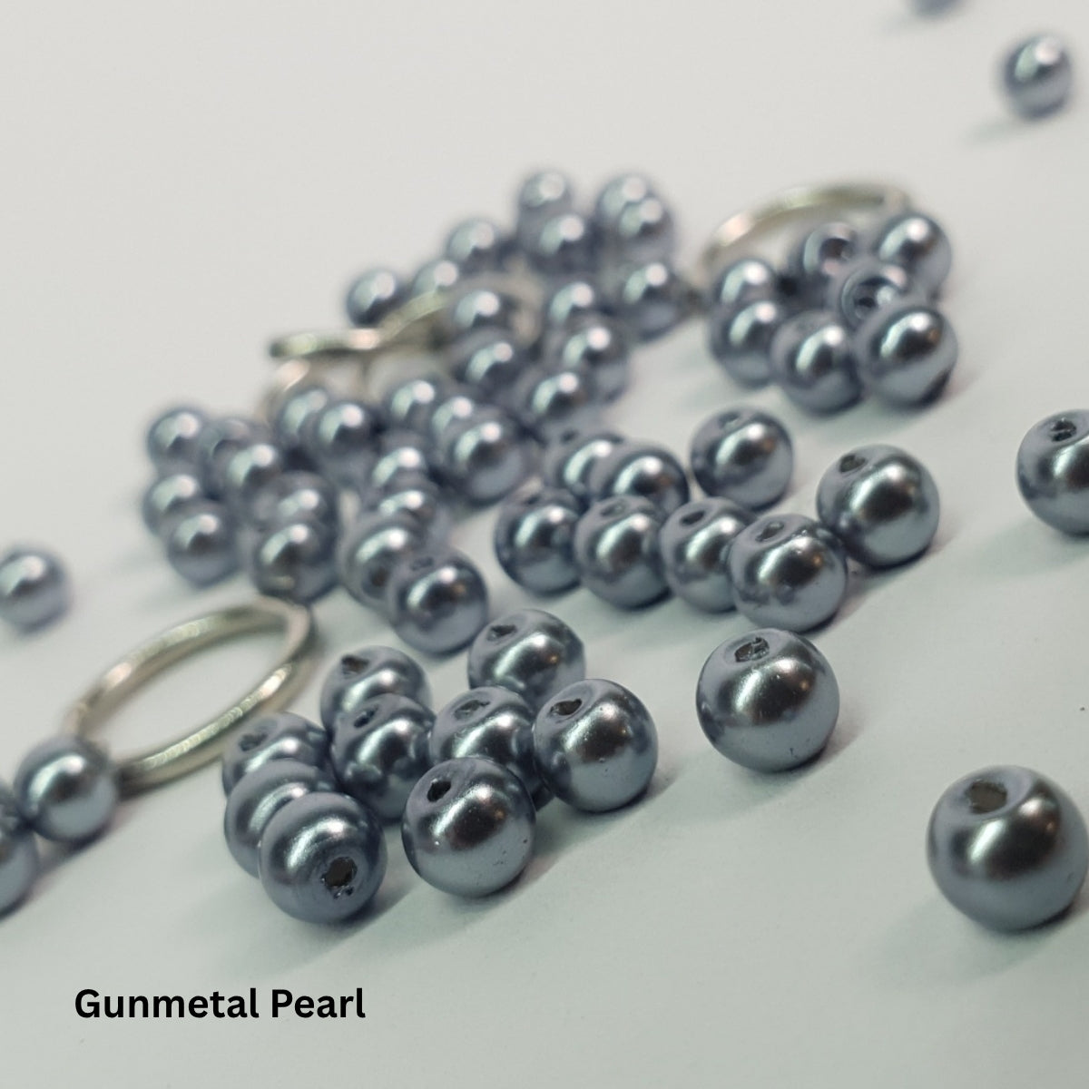 Close-up of dark gunmetal glass pearls combined with stainless steel chainmail rings.