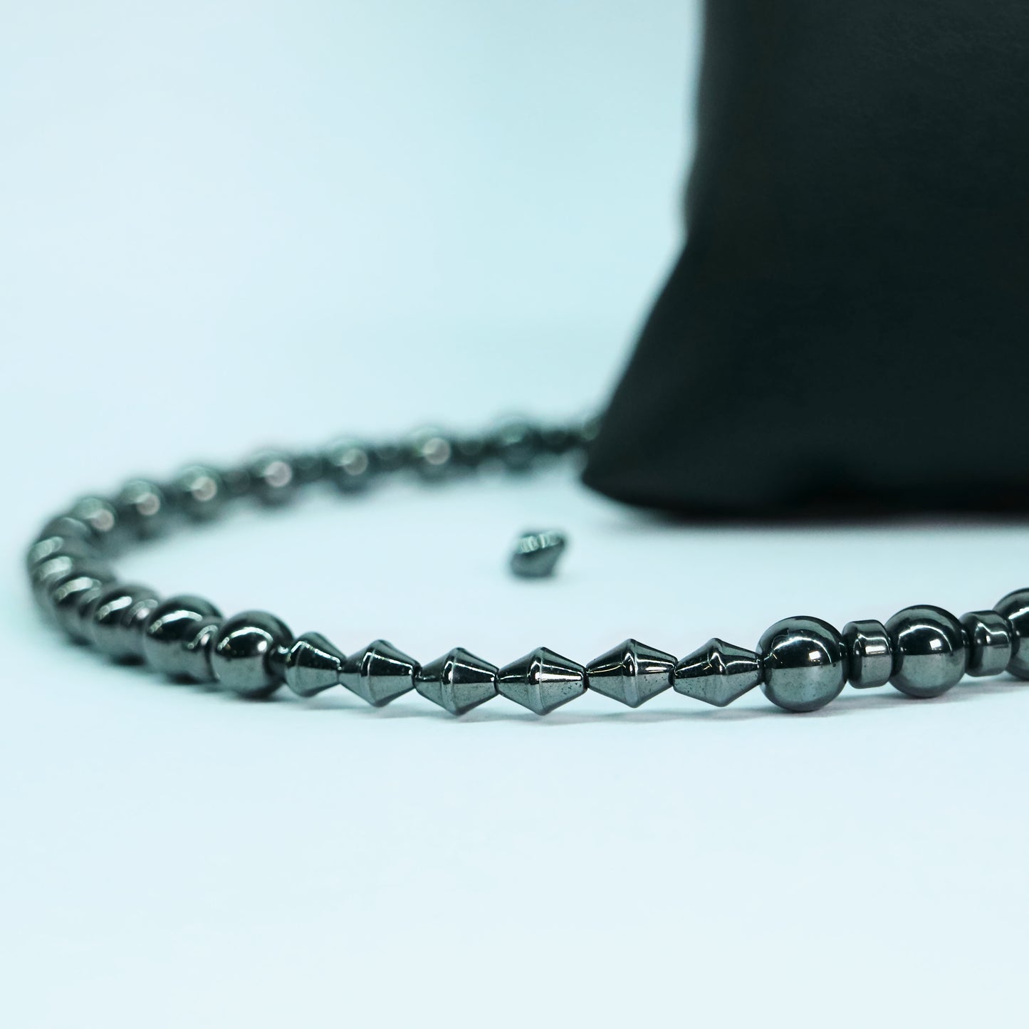 Close-up of glossy white natural stones with grey veining and silver hematite beads leading into the stainless steel O-ring and chainmail boxchain center.