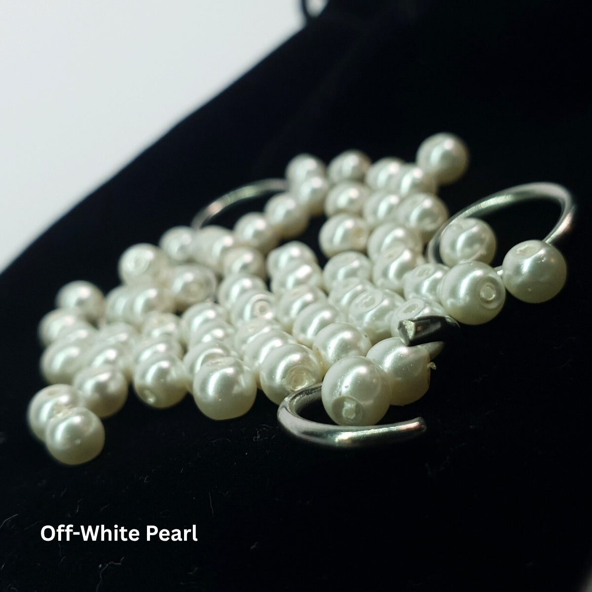 Close-up of off-white glass pearls used in a stainless steel chainmail choker.