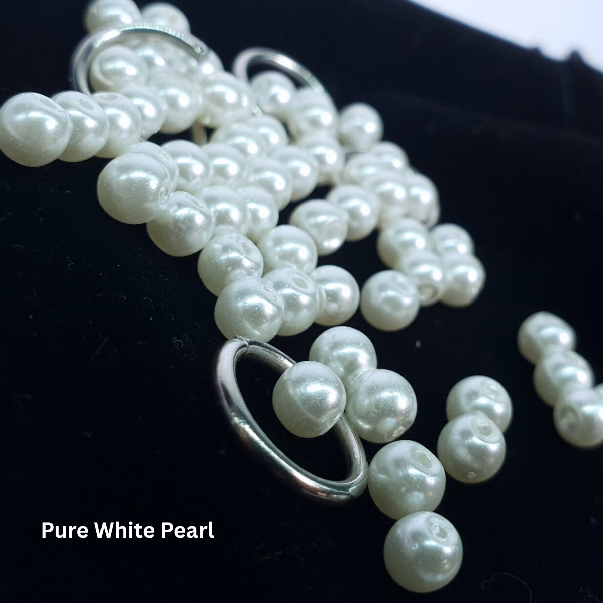 Close-up of pure white glass pearls paired with stainless steel rings for the chainmail choker.