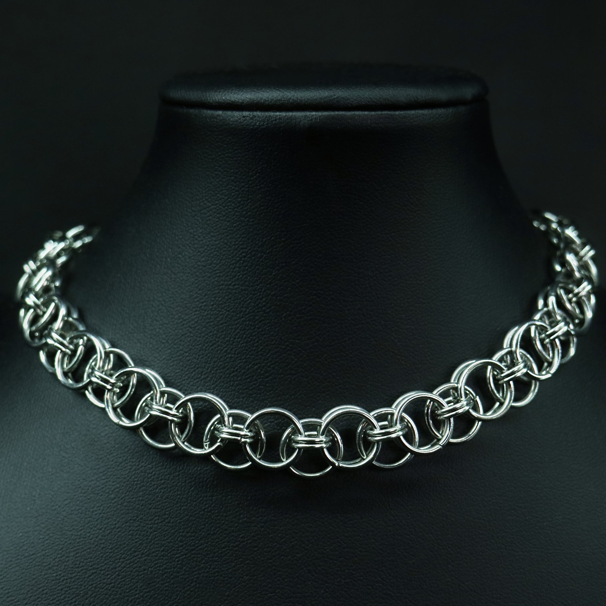 Front view of a handmade stainless steel chainmail choker with interlinked rings and a polished, structured weave.