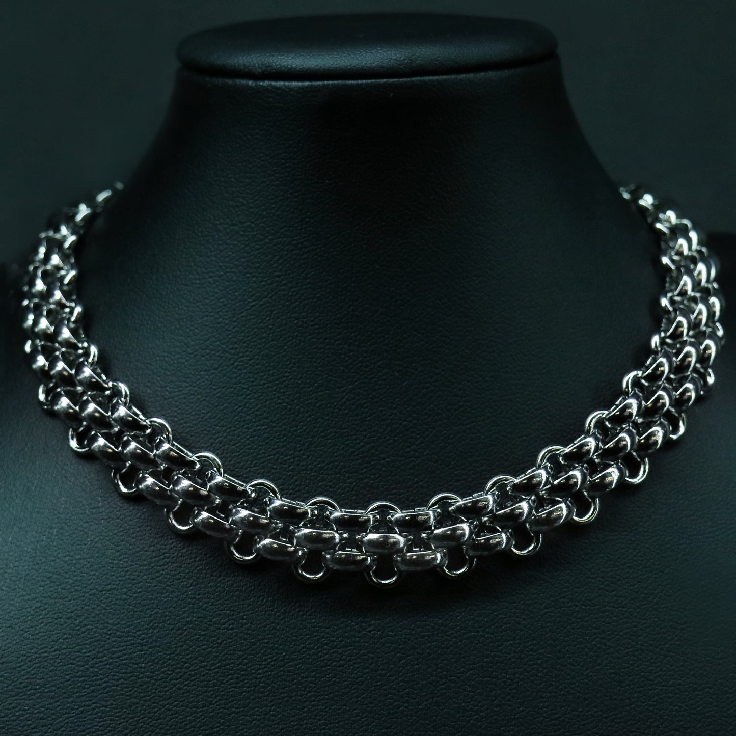 Front view of the stainless steel flat weave chain with a structured, low-profile interlocked design.