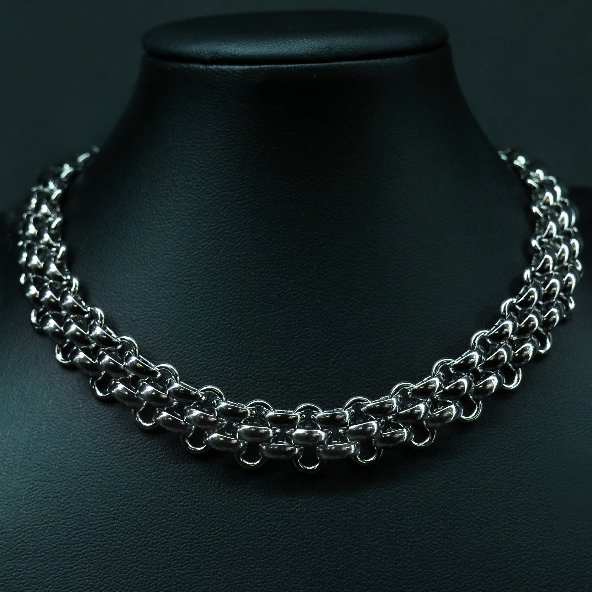 Front view of the stainless steel flat weave chain with a structured, low-profile interlocked design.