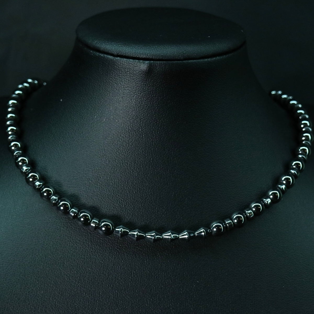 Front view of the white stone and hematite bead necklace transitioning into a stainless steel boxchain O-ring centerpiece.
