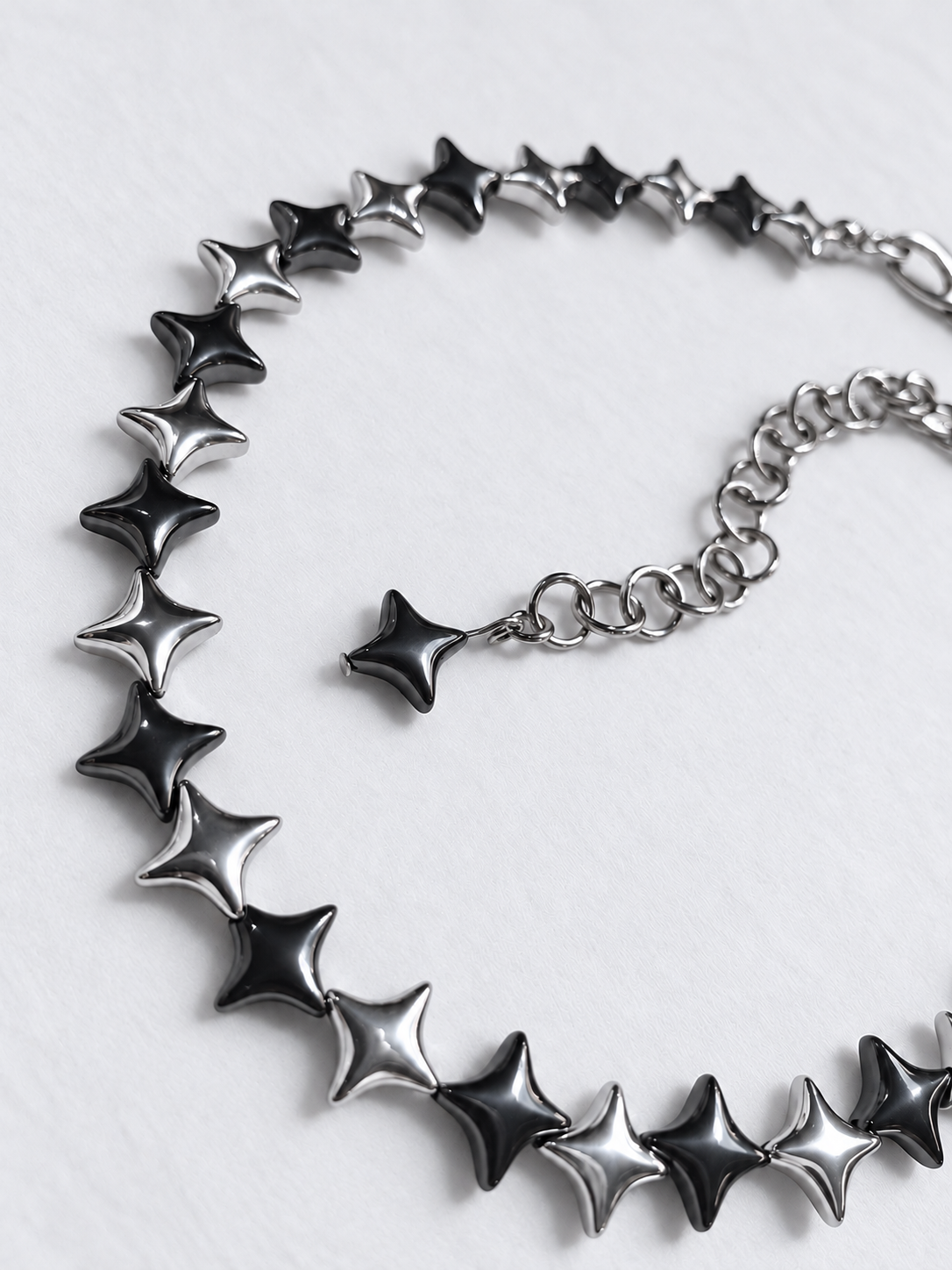 Close-up of NORTHLINE Mixed silver and gunmetal North Star hematite beads and stainless steel extension ending in a gunmetal star.