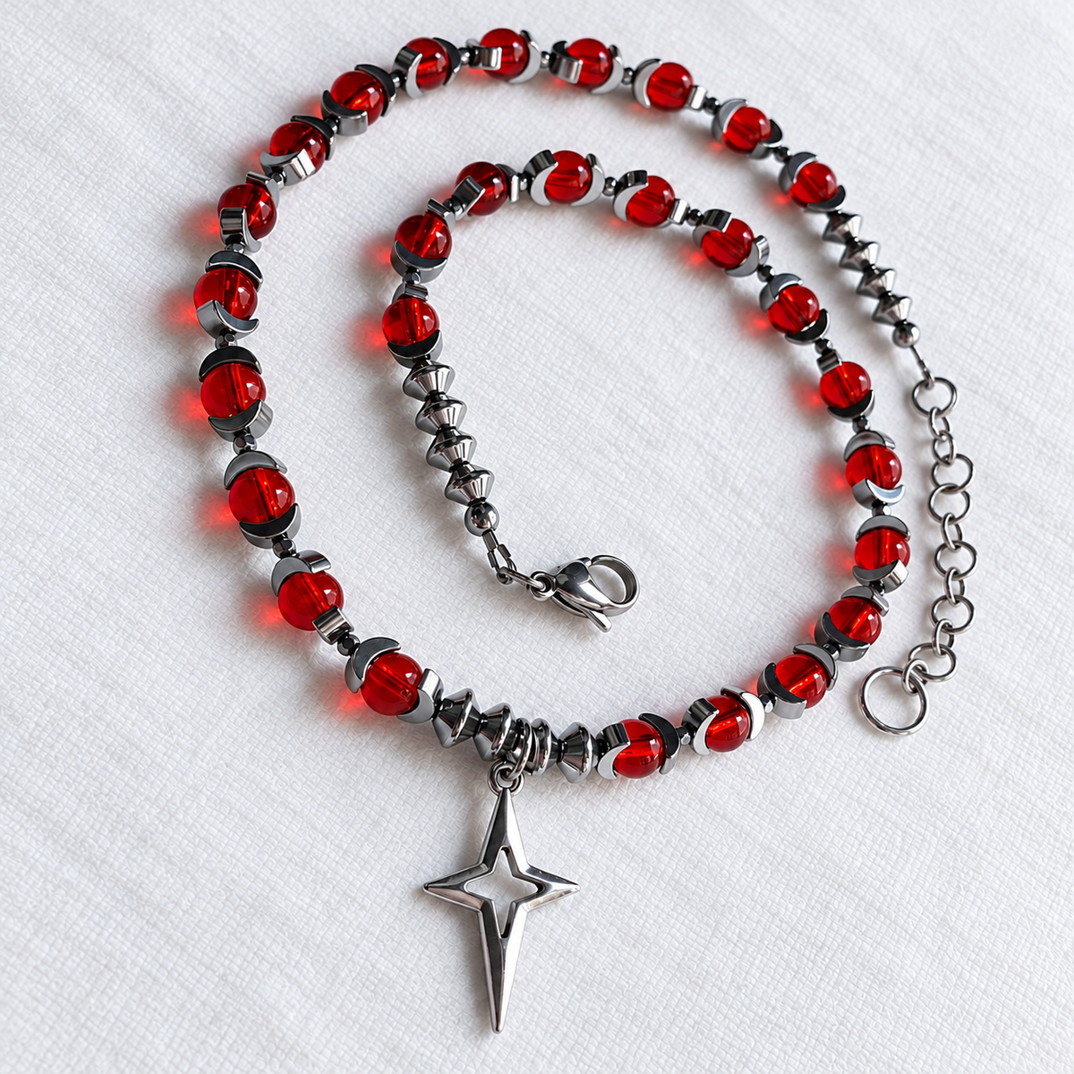 CELESTIA red glass and silver hematite necklace with North Star pendant, angled full view.