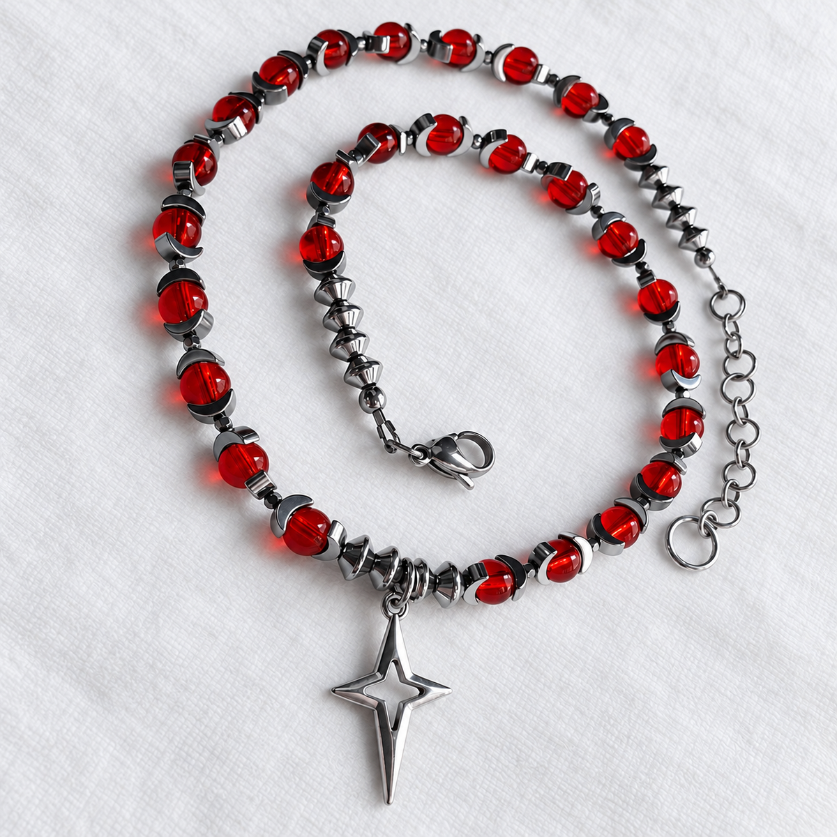 CELESTIA red glass and silver hematite necklace with crescent beads and North Star pendant, full view.