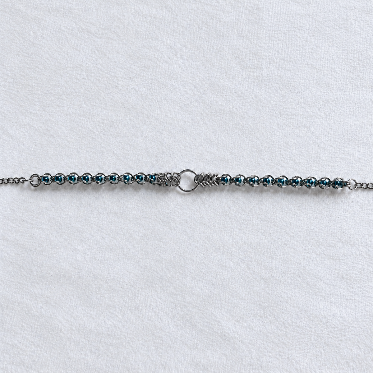 ECHO choker's teal glass pearl and stainless steel chainmail front section with central O-ring.