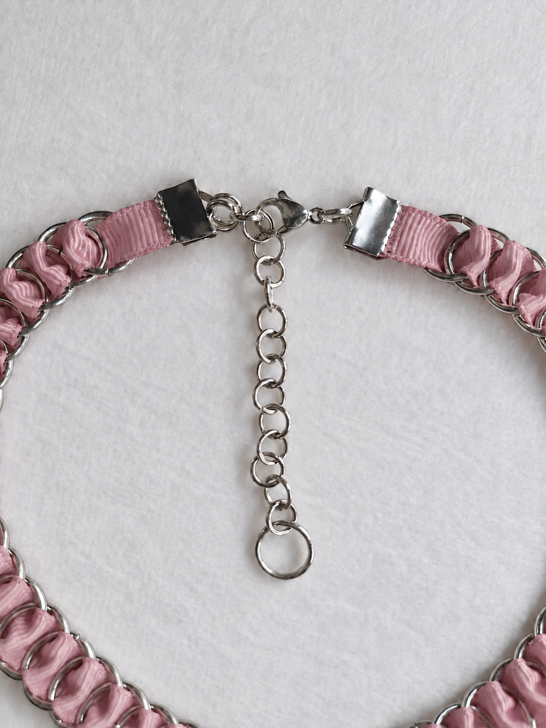 LOOM dusty pink choker fastening detail showing stainless steel ribbon clamps, lobster clasp and adjustable extension chain.
