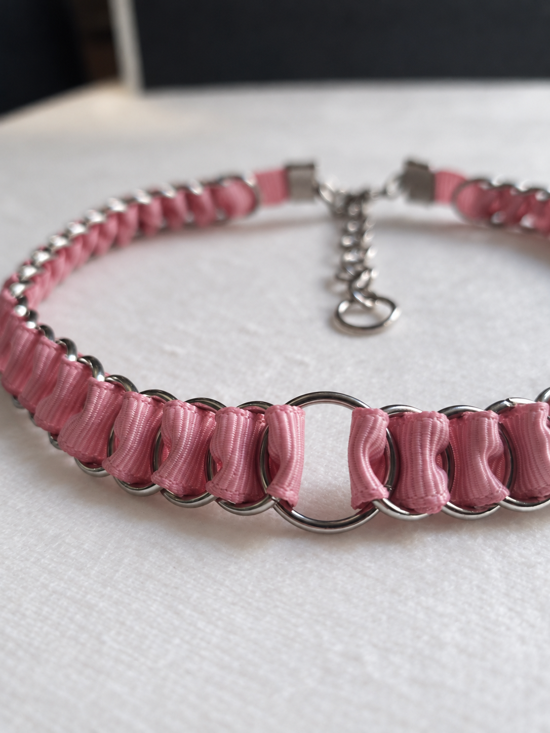Front detail of the LOOM dusty pink choker showing folded ribbon and the central stainless steel O-ring.