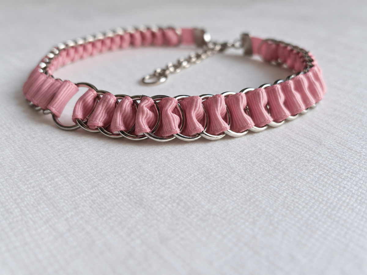 Side detail of dusty pink ribbon folds woven through interlinked stainless steel rings on the LOOM choker.