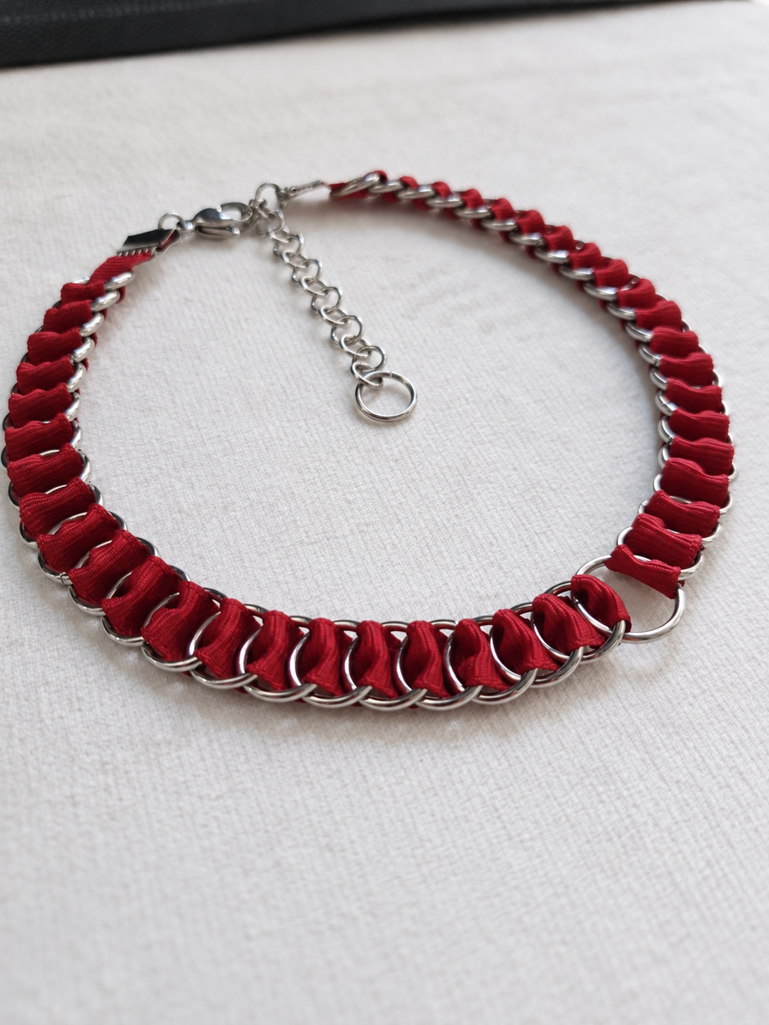 Angled view of the full LOOM red fabric ribbon chainmail choker with stainless steel O-ring and adjustable extension chain.
