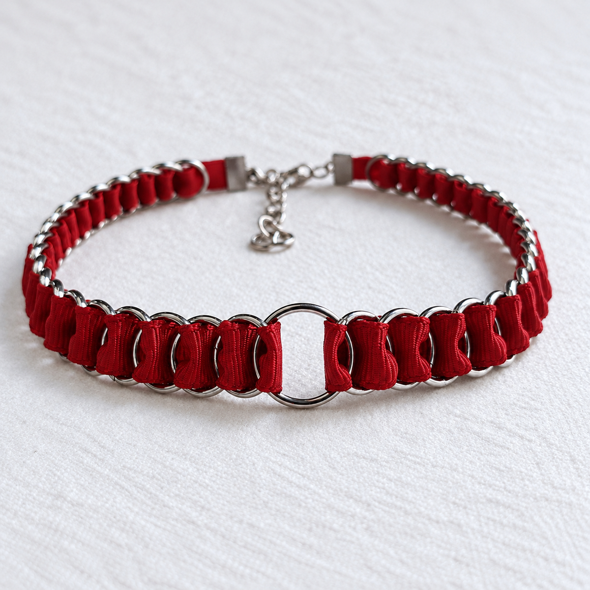 LOOM red fabric ribbon chainmail choker with polished stainless steel rings and a central O-ring, shown on white fabric.