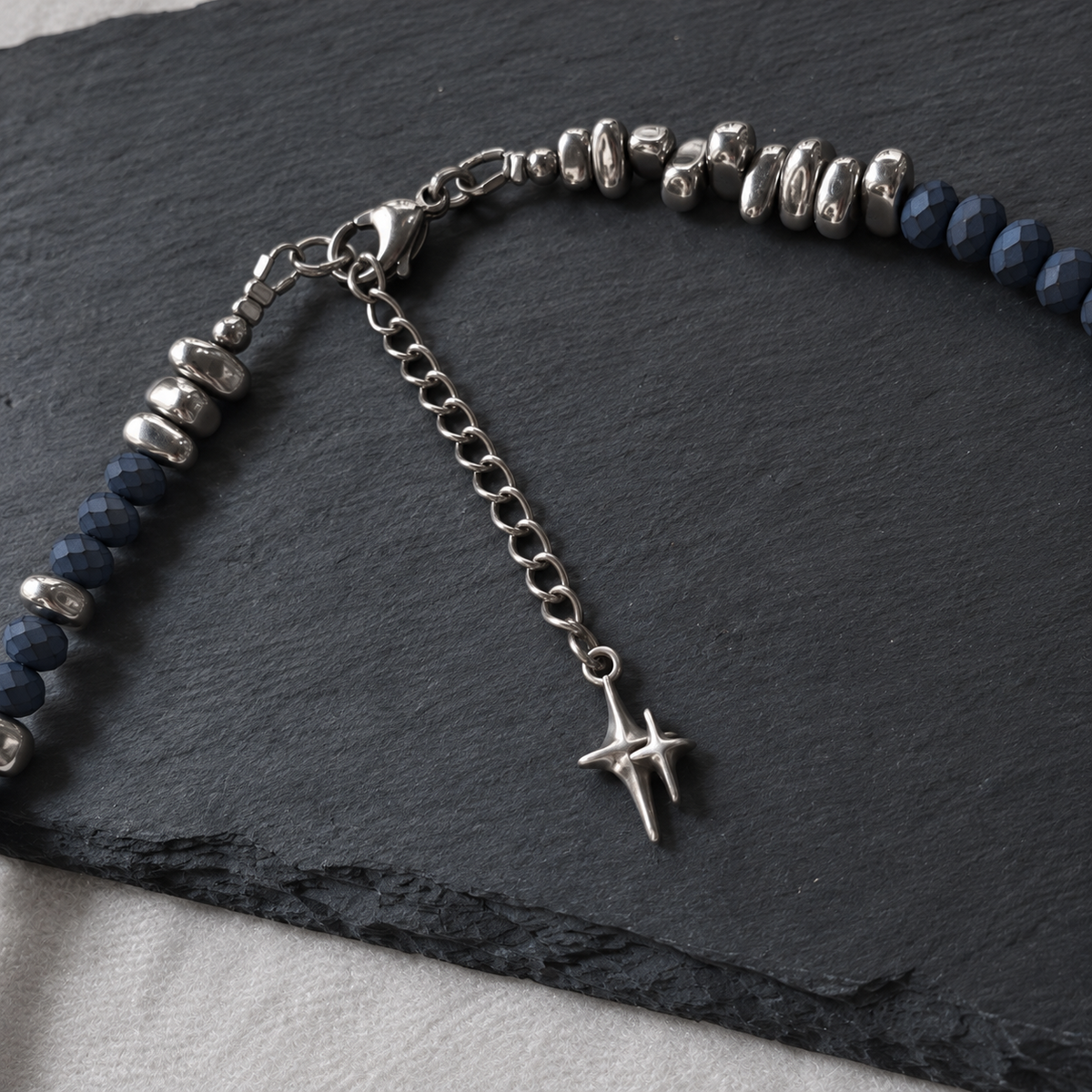 NIGHTMARK necklace's stainless steel lobster clasp and extension chain ending in a silver-plated North Star charm.