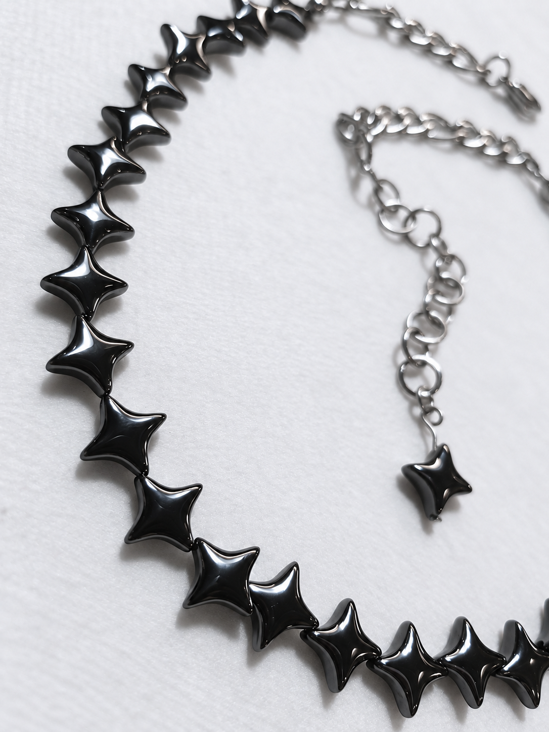 Close-up of polished gunmetal North Star hematite beads and stainless steel extension on the NORTHLINE choker.