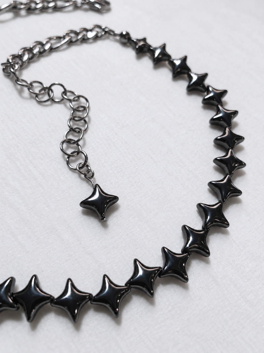 NORTHLINE Gunmetal choker detail showing polished hematite stars and stainless steel extension ending in a matching gunmetal star.