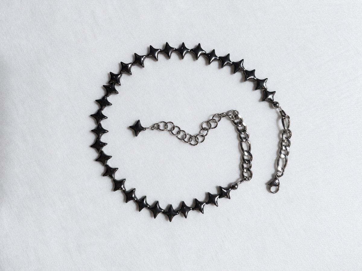 Overhead view of the complete NORTHLINE Gunmetal hematite star choker with stainless steel chains and adjustable extension.