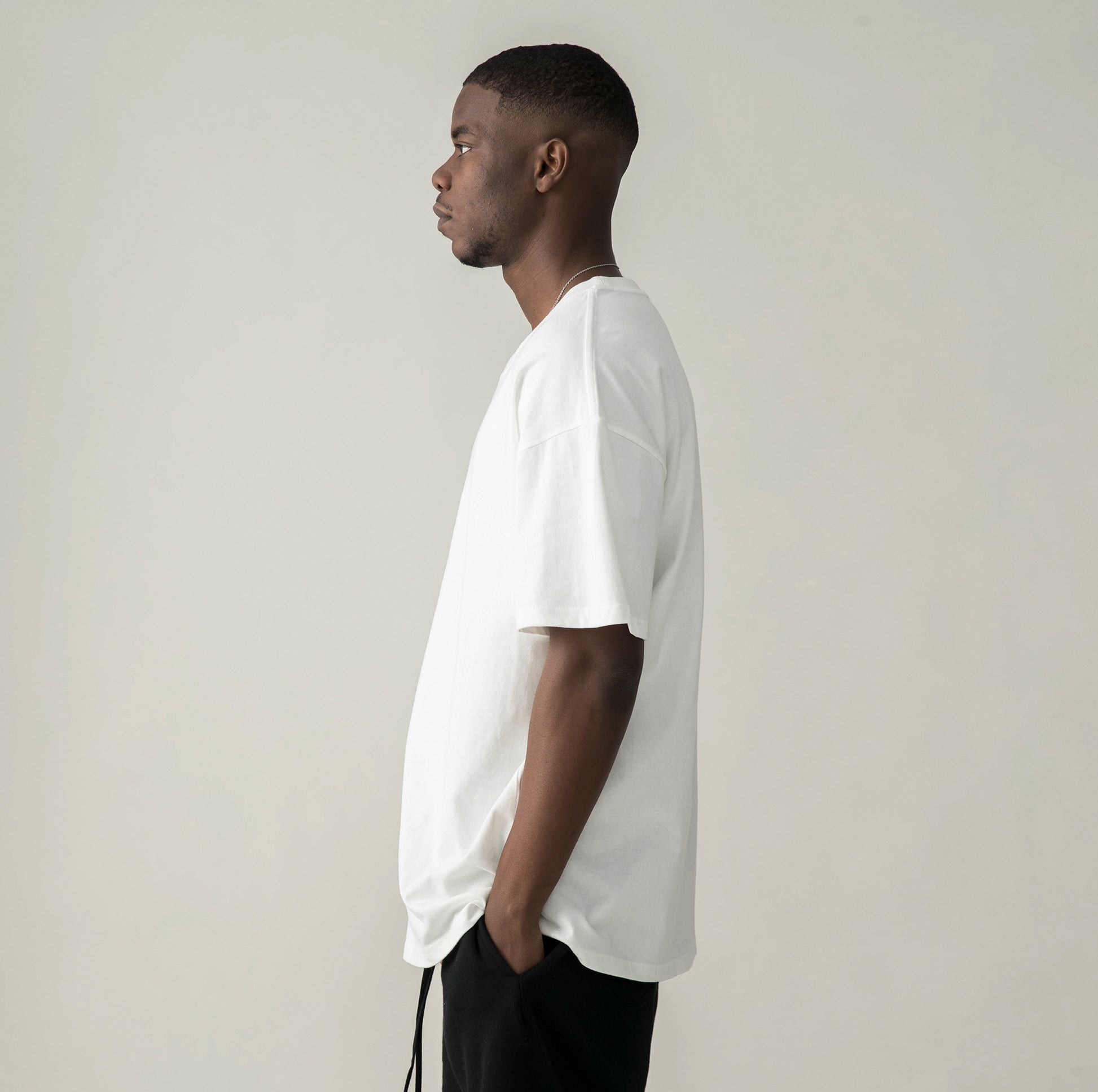 Side view of model in $MILE (BACK PRINT) - Unisex Oversized T-shirt (WHITE))